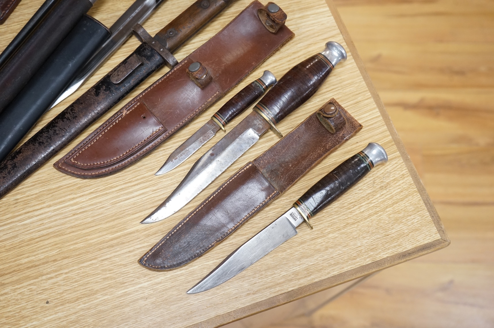 A 1907 bayonet by Wilkinson in its steel mounted leather scabbard, another similar with leather frog, two small British bayonets, a Continental bayonet, and two assorted hunting knives (7)